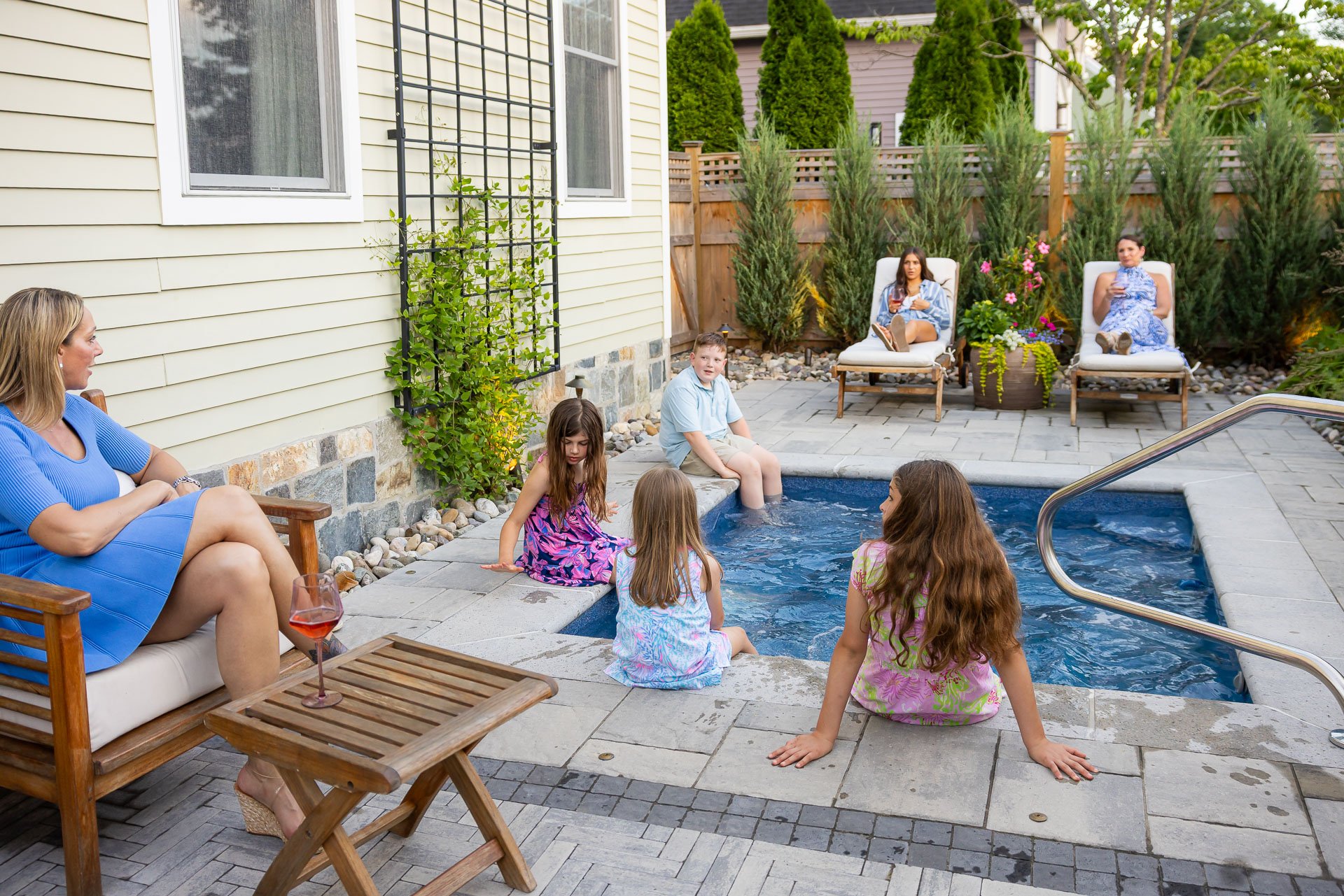 family relaxing on their pool deck