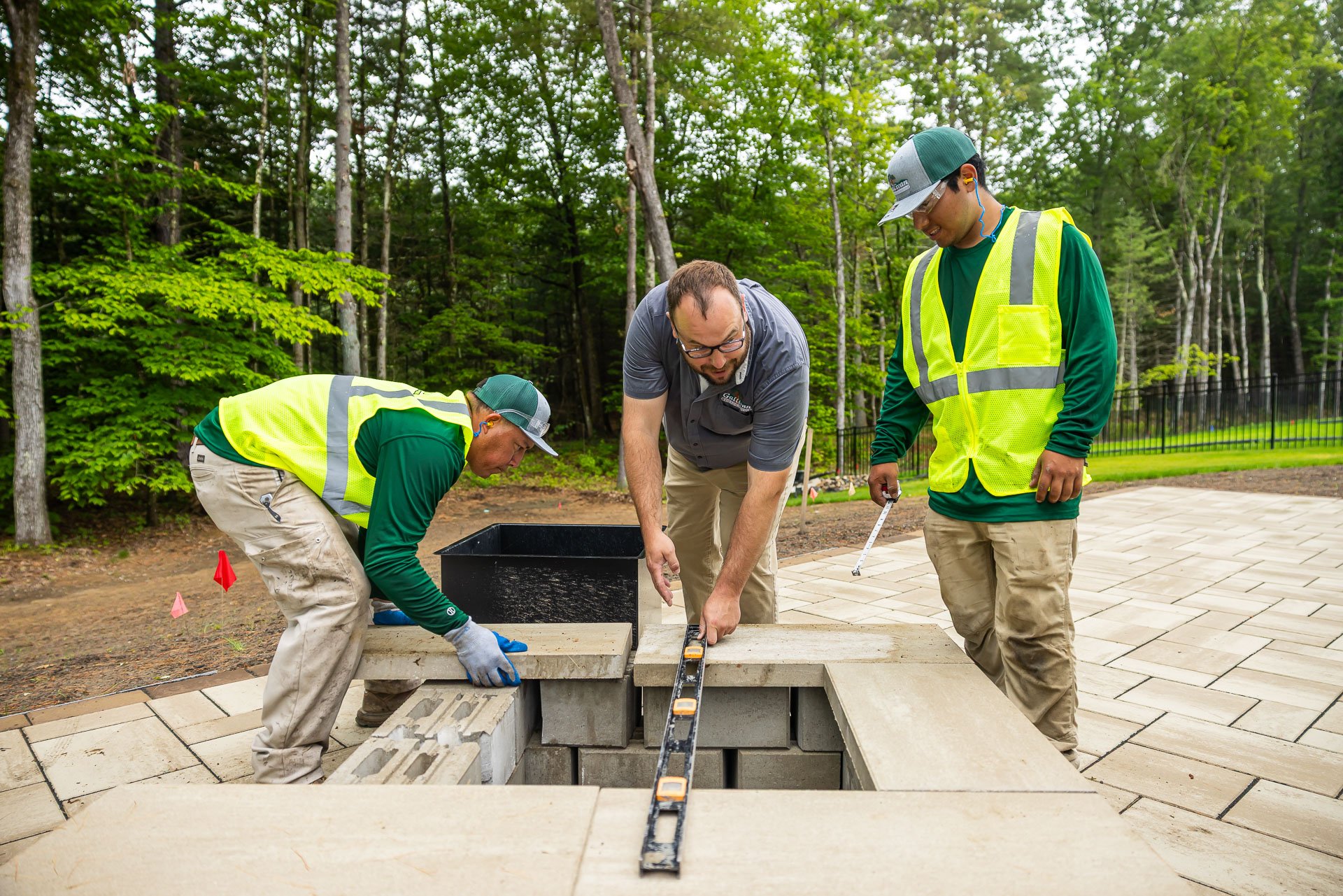 construction crew installing a firepit with designer