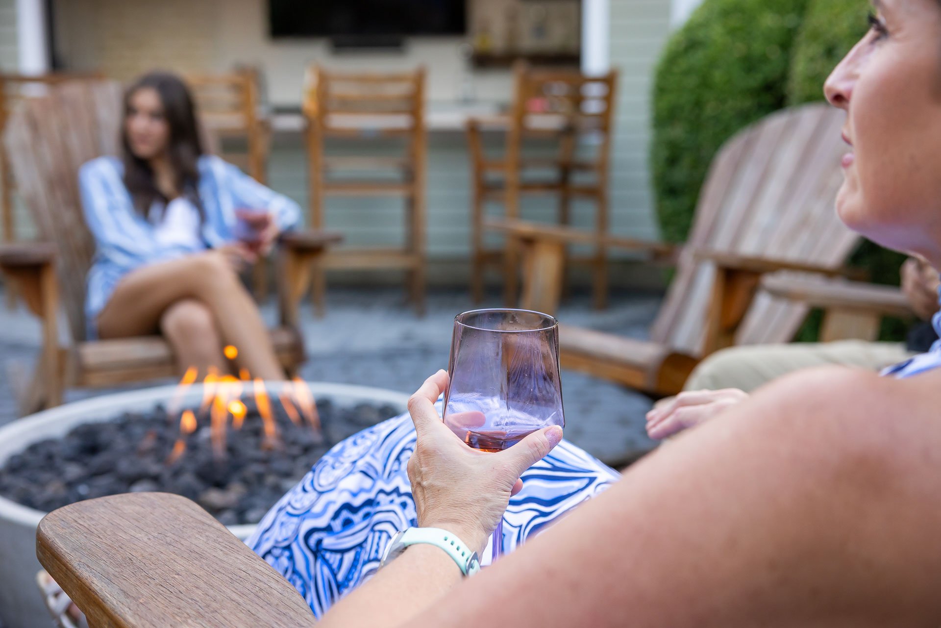 client enjoying a drink by their firepit
