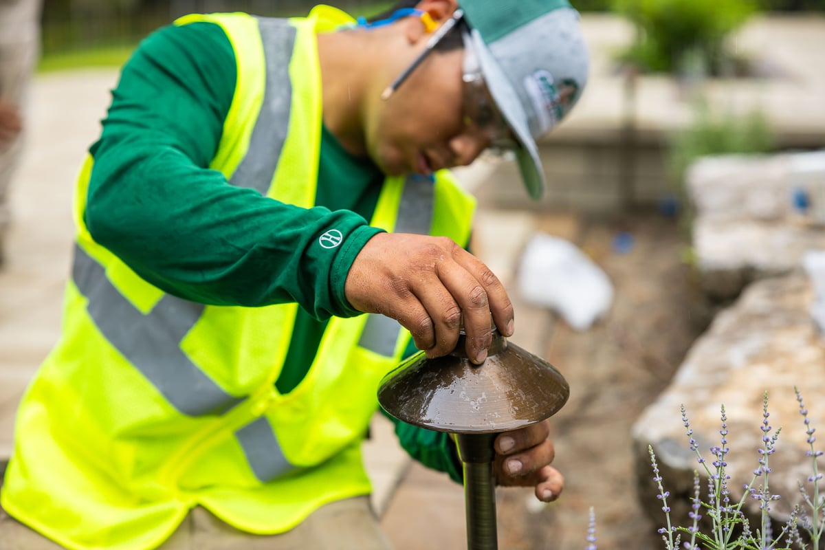 technician installing landscape path light