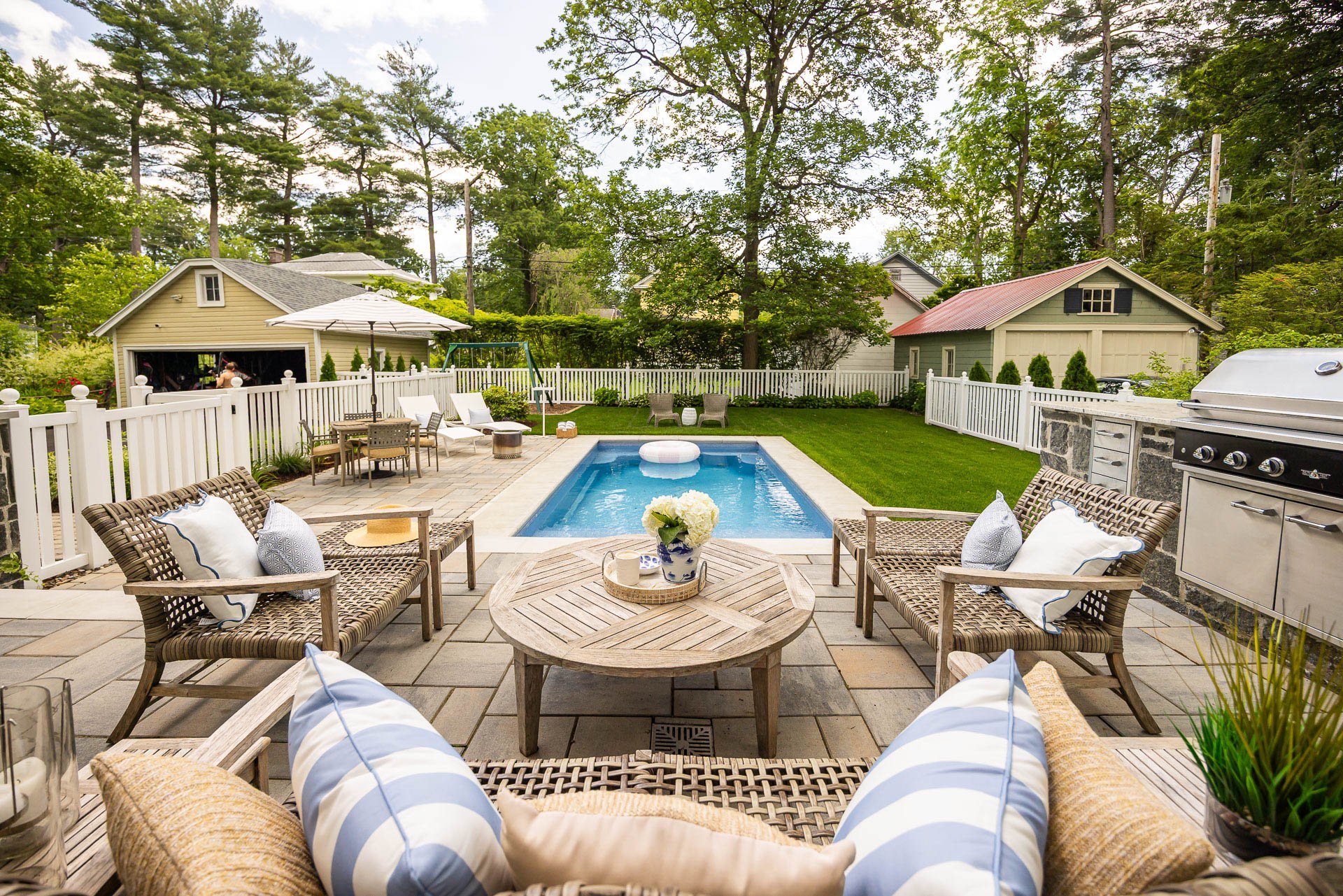 a stone patio with seating area overlooking a pool