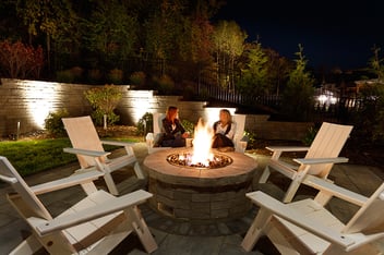people gathered around an outdoor fire feature