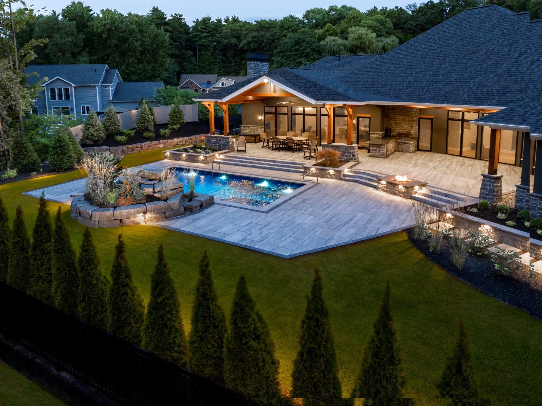 landscape lighting waterfeature pool deck backyard screening plants patio seating