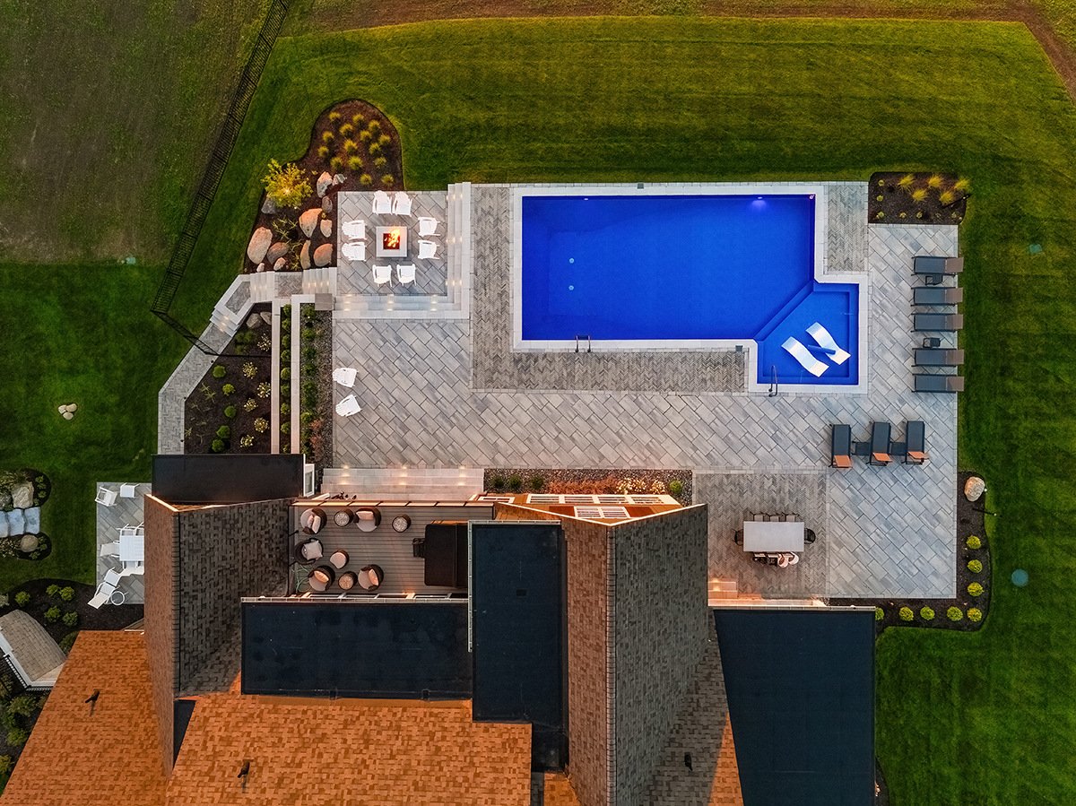 aerial view of a pool within a landscape surrounded by a stone patio