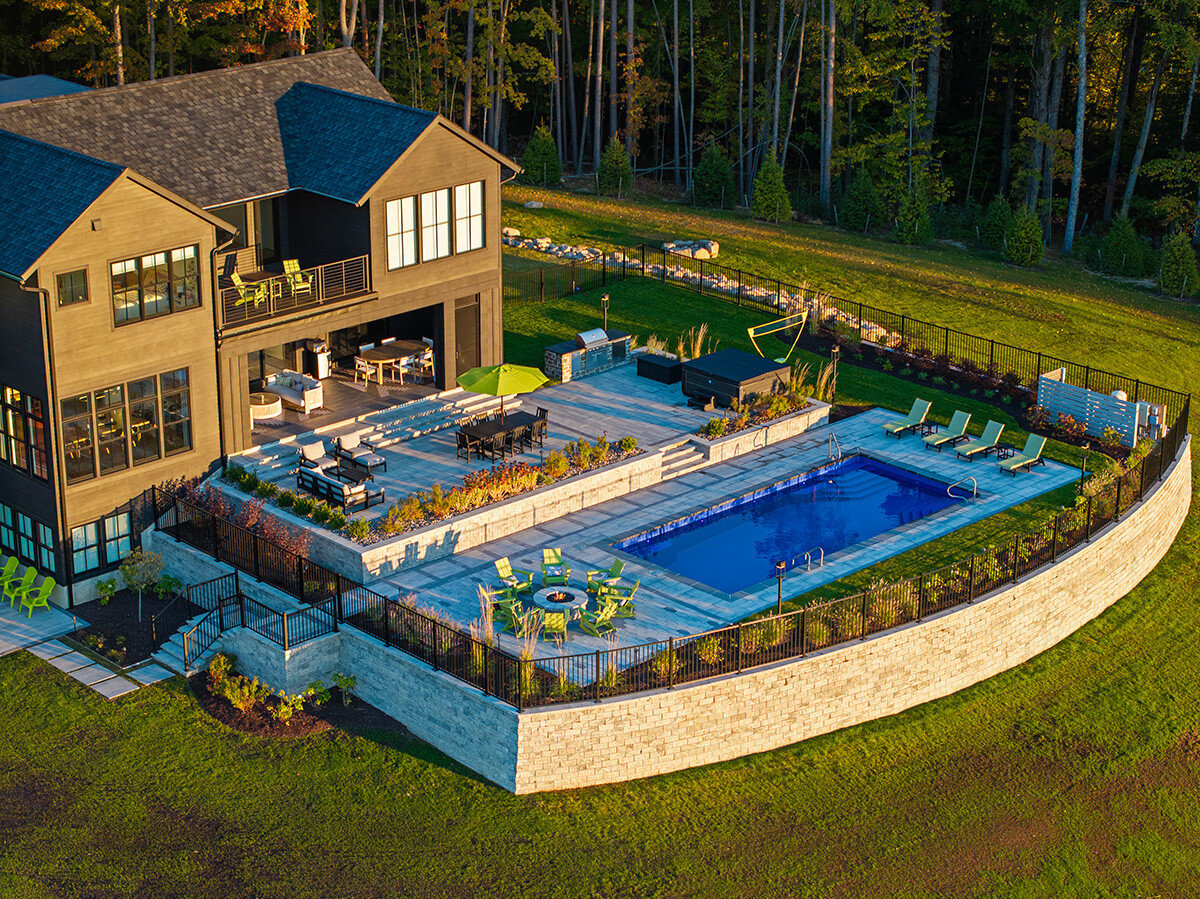 fully landscaped pool area with patio, fire pit, and plants