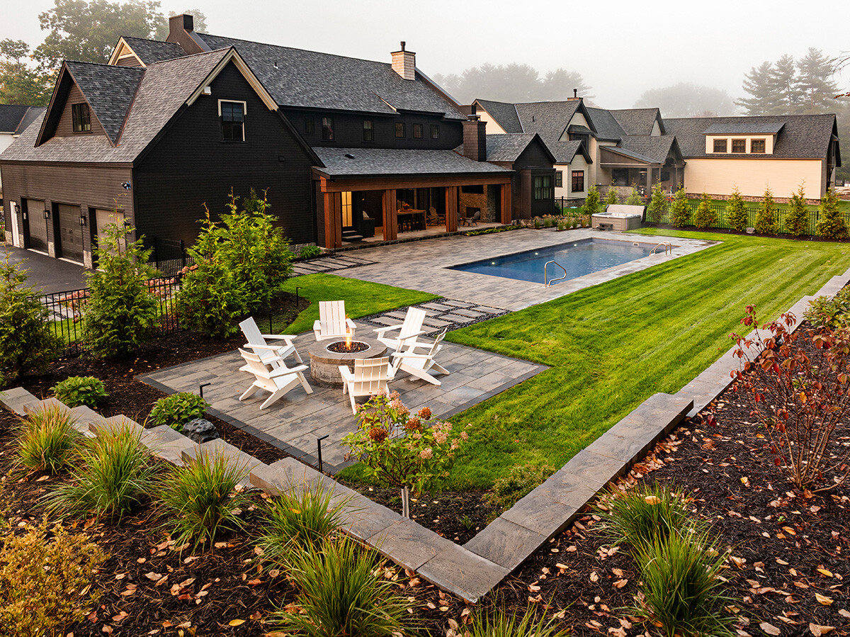 landscape project with a patio, firepit, pool, and lawn