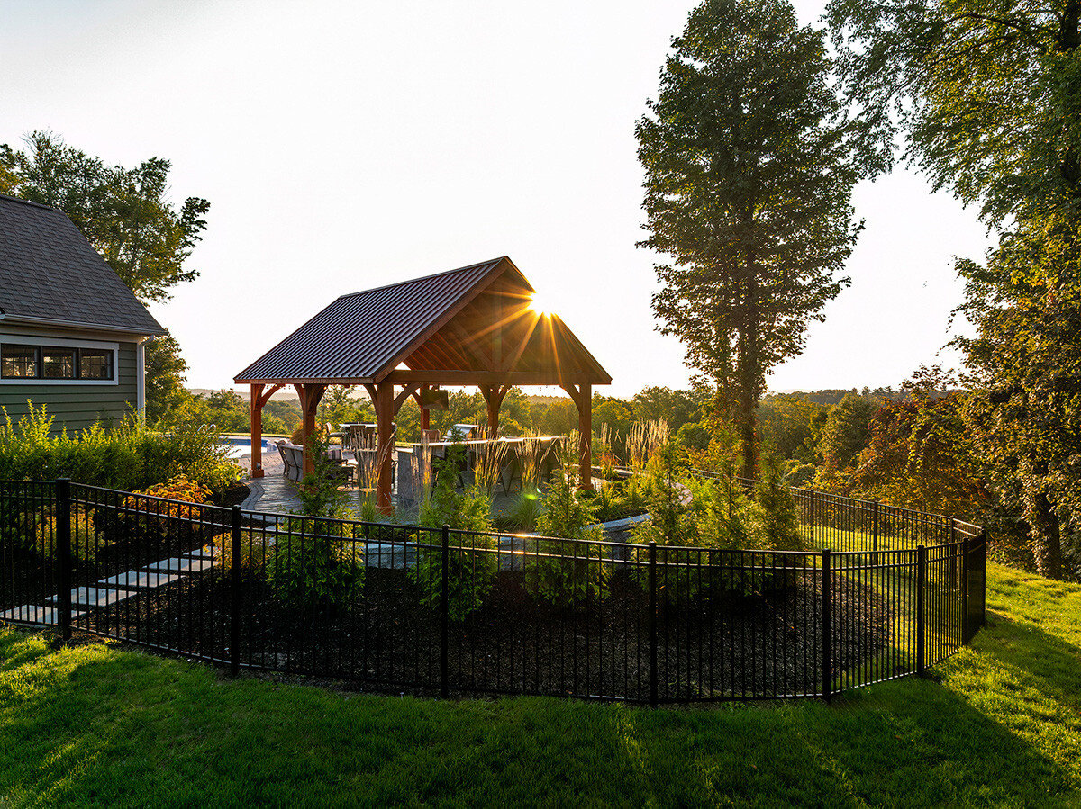 sunrise behind a pergola surrounded by native plants