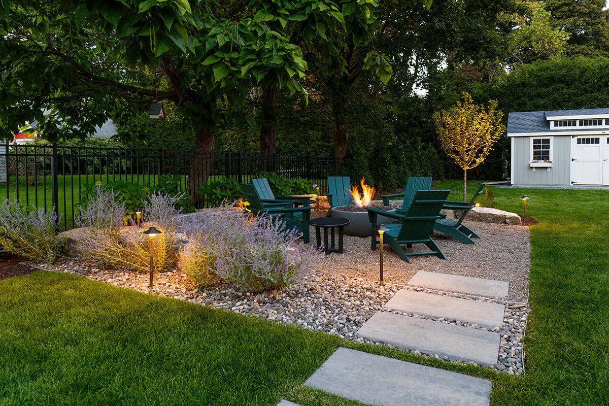 a gravel seating area with a fire pit at the focal center