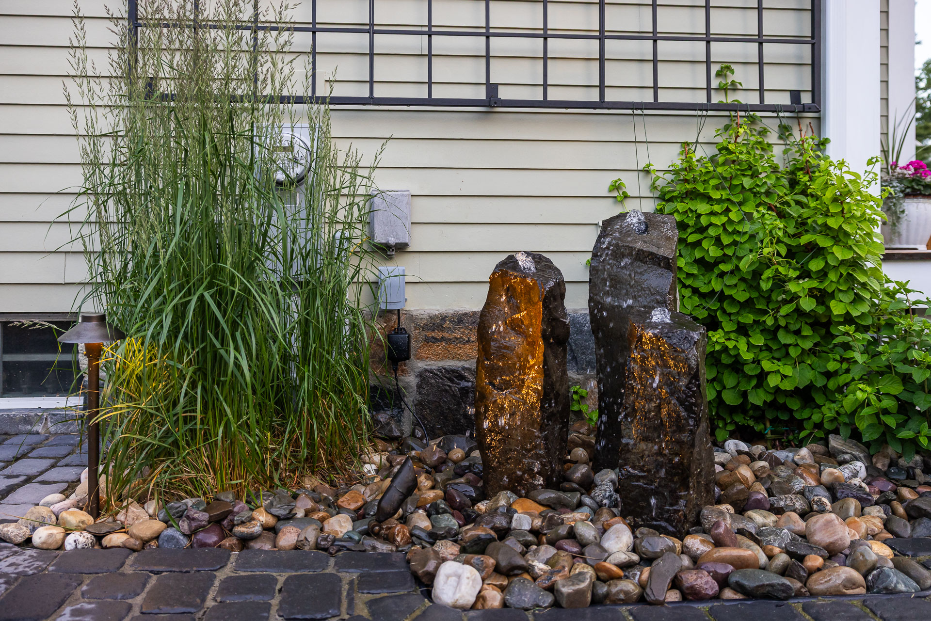 detail landscape path up spot light basalt water feature columns gravel stone