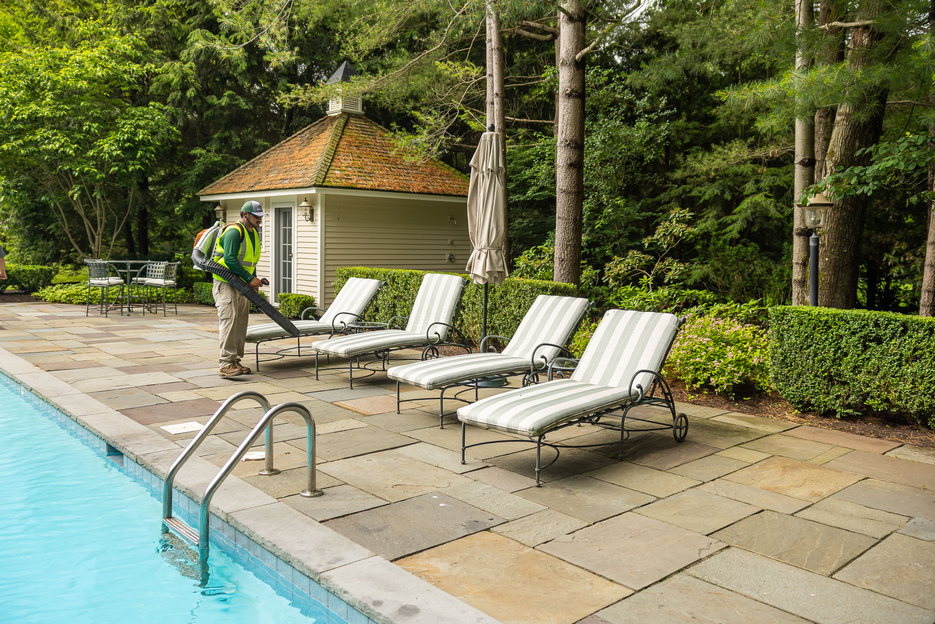 maintenance crew blow pool deck clean leaves