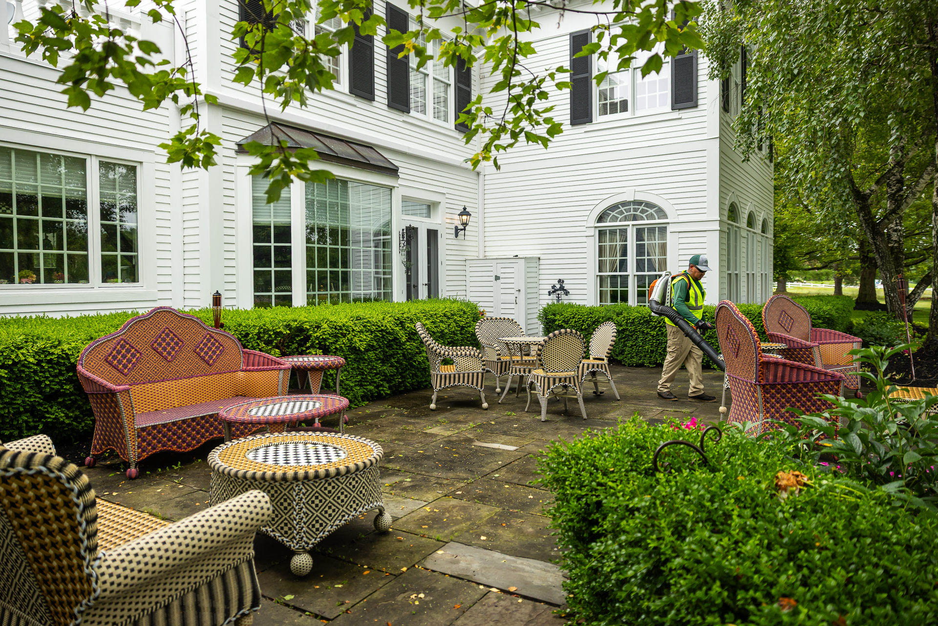 maintenance crew clean up backpack blower patio leaves