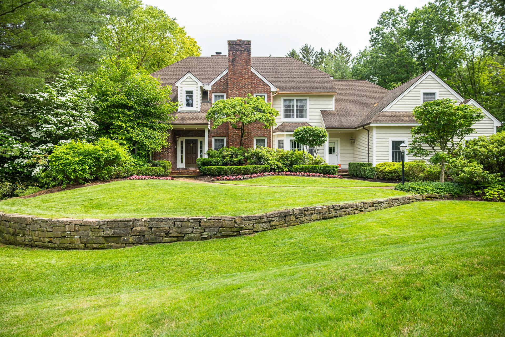 nice green grass shrubs planting bed home retaining wall dry stack