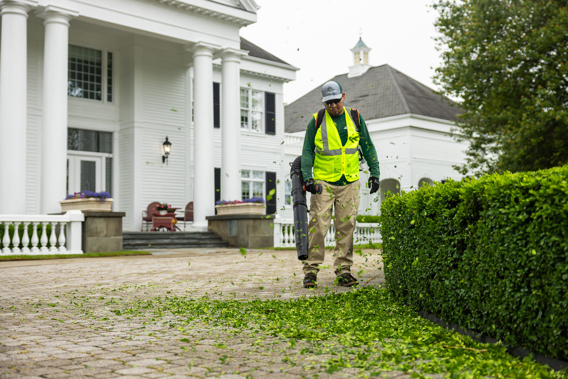 nice maintenance crew leaves cleanup backpack blower paver driveway