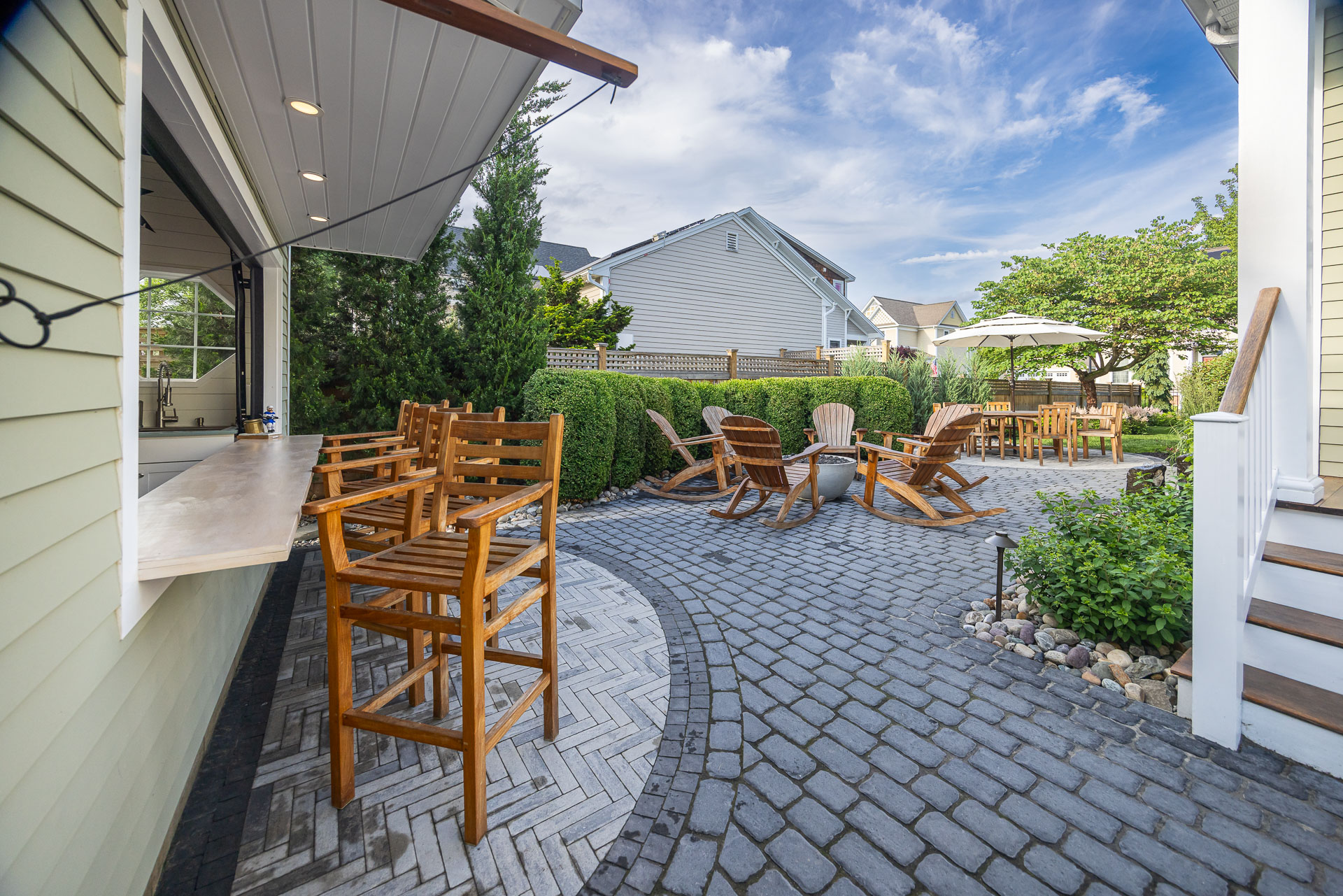 https://241926021.fs1.hubspotusercontent-na2.net/hubfs/241926021/Images/2025%20Photo%20Shoot%20-%20Renamed/nice%20paver%20patio%20pool%20house%20bar%20top%20counter%20firepit%20chairs%20landscape%20path%20light.jpg