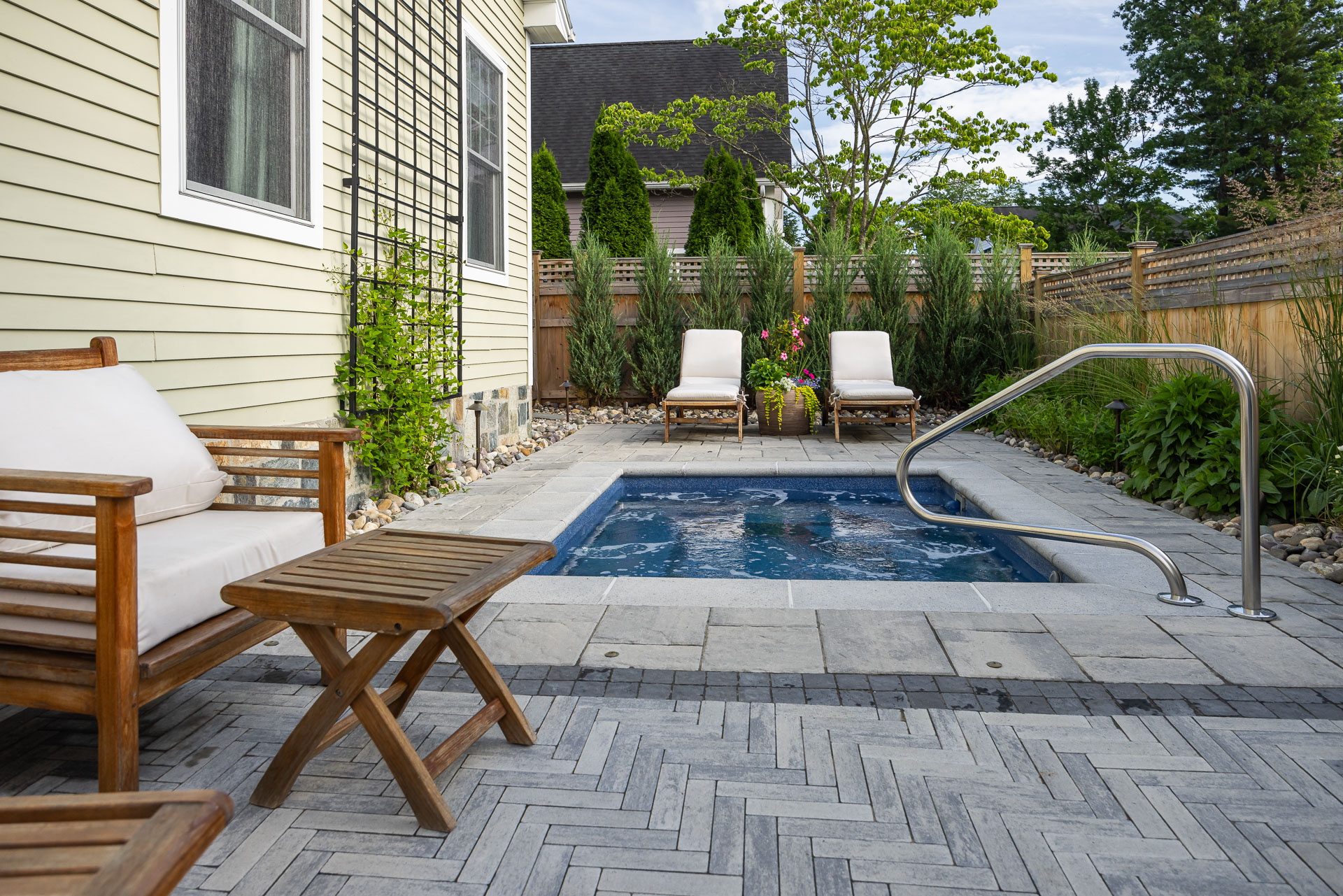 nice small backyard pool chairs seating flowers gravel bed trellis tree paver patio
