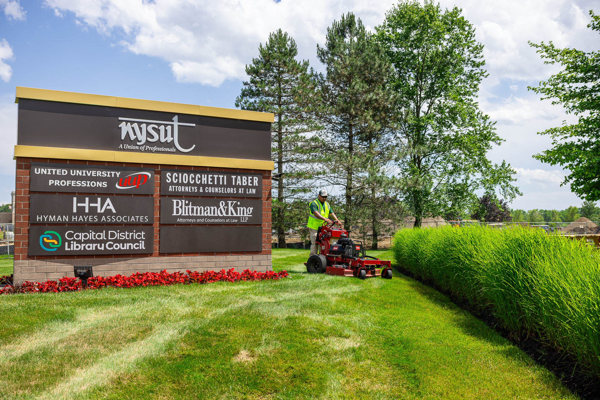 nysut commercial crew mowing grass signage