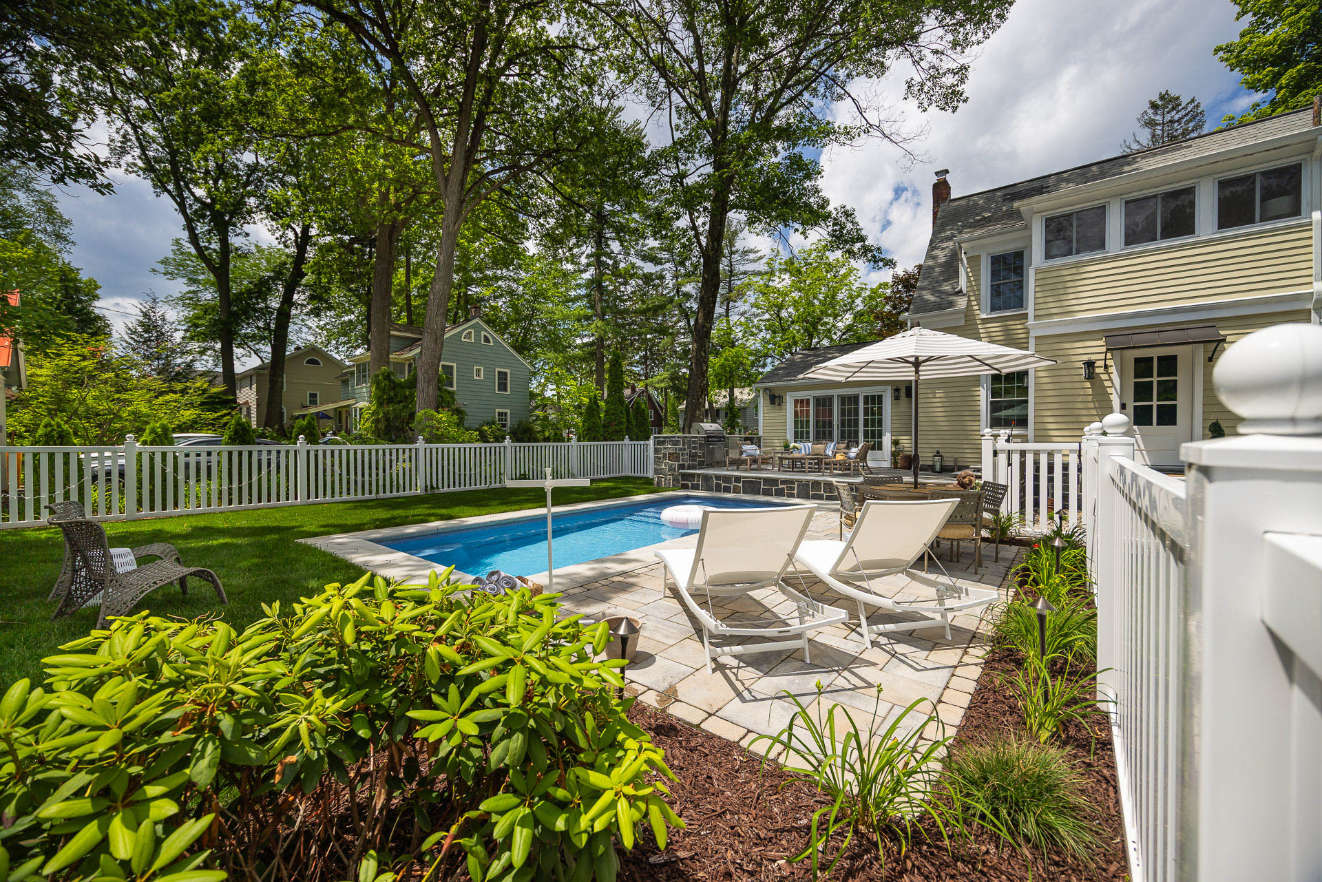 shrubs patio seating pool planting bed fence stone