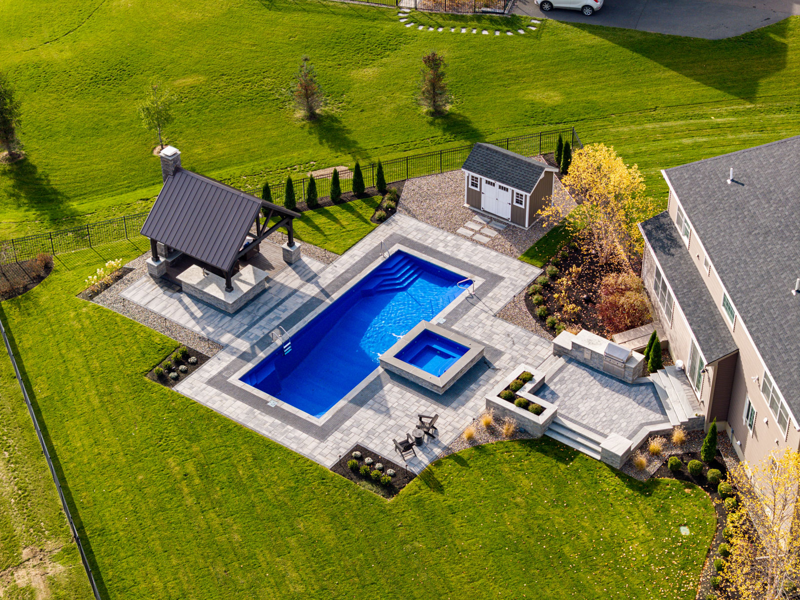 pool paver patio hot tub spa integrated pergola shed stairs kitchen aerial home yard lawn riccio